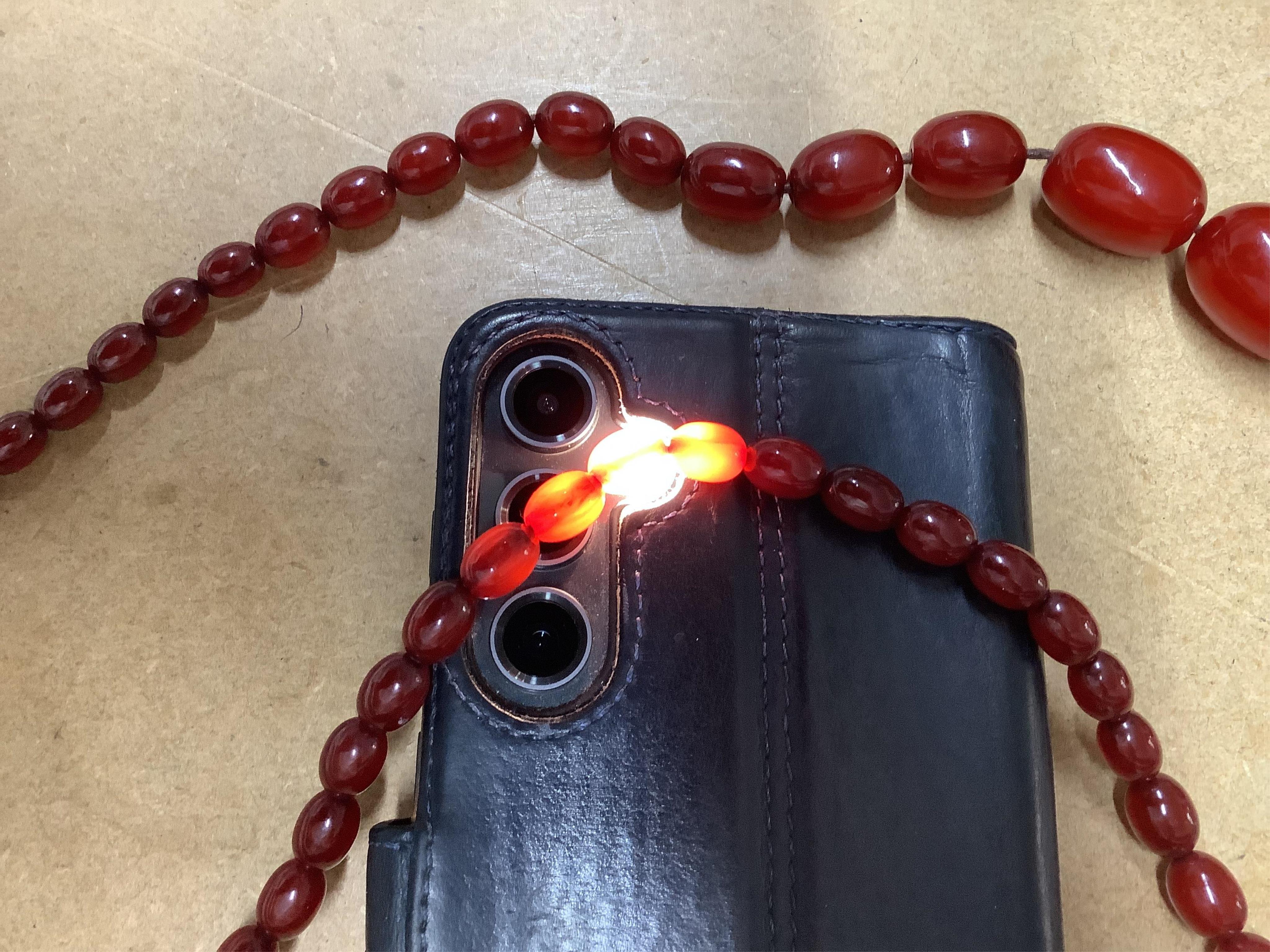 A single strand graduated simulated cherry amber bead necklace, 76cm, gross weight 75 grams.